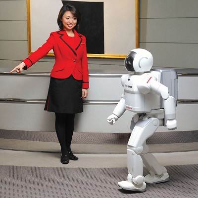 press release photo of 2002 variant of Asimo walking to area pointed at by presenter